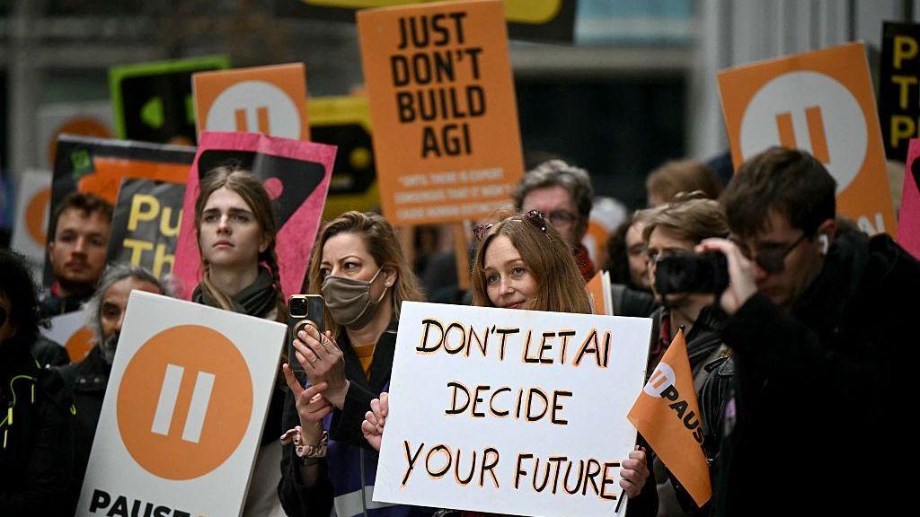 Un grupo de activistas en una protesta en Londres en febrero. Una mujer sostiene un cartel que dice "No dejes que la IA decida tu futuro". Detrás de ella, otro cartel dice "Simplemente no construyan IA general".