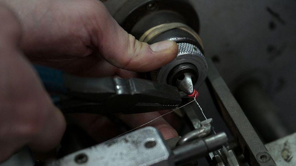 Trabajador con un torno de metal.