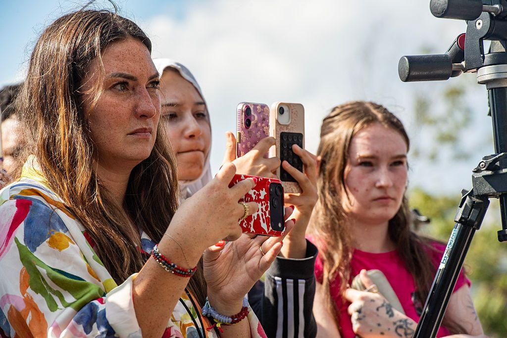 Un grupo de mujeres jóvenes con sus teléfonos afuera del juicio