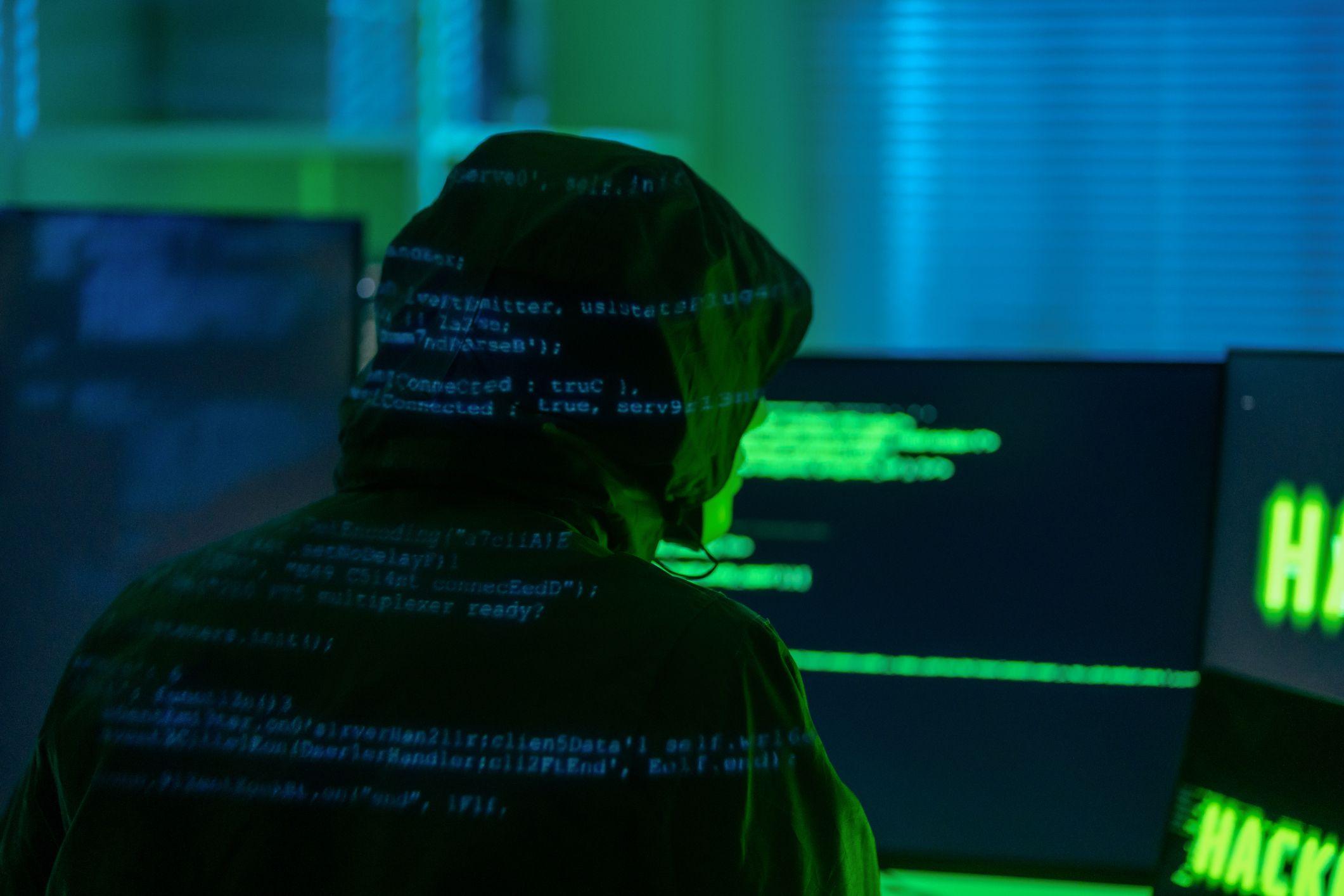 Un hacker de espaldas frente a un computador.