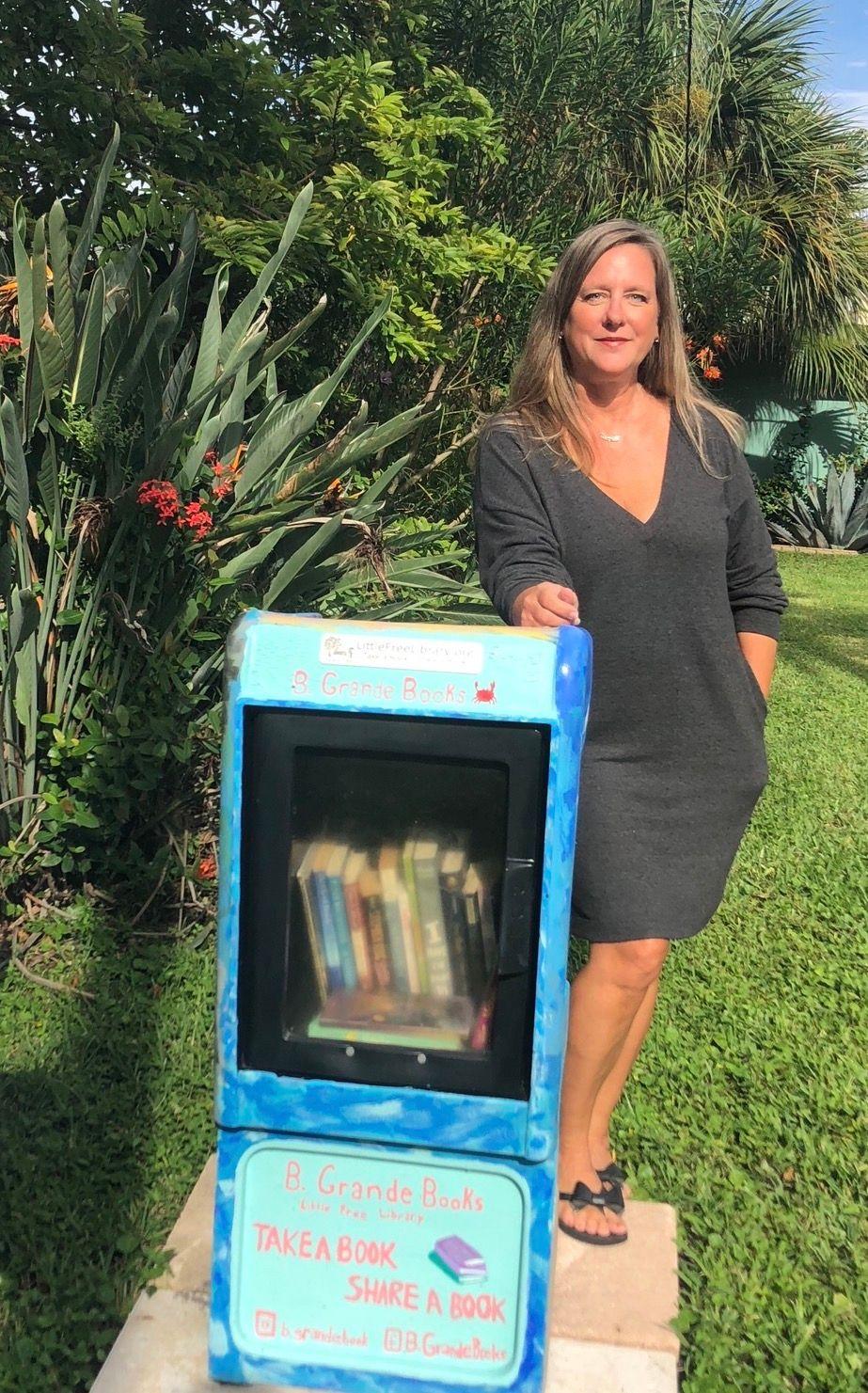 Nicole St. Leger junto a su pequeña biblioteca gratuita.