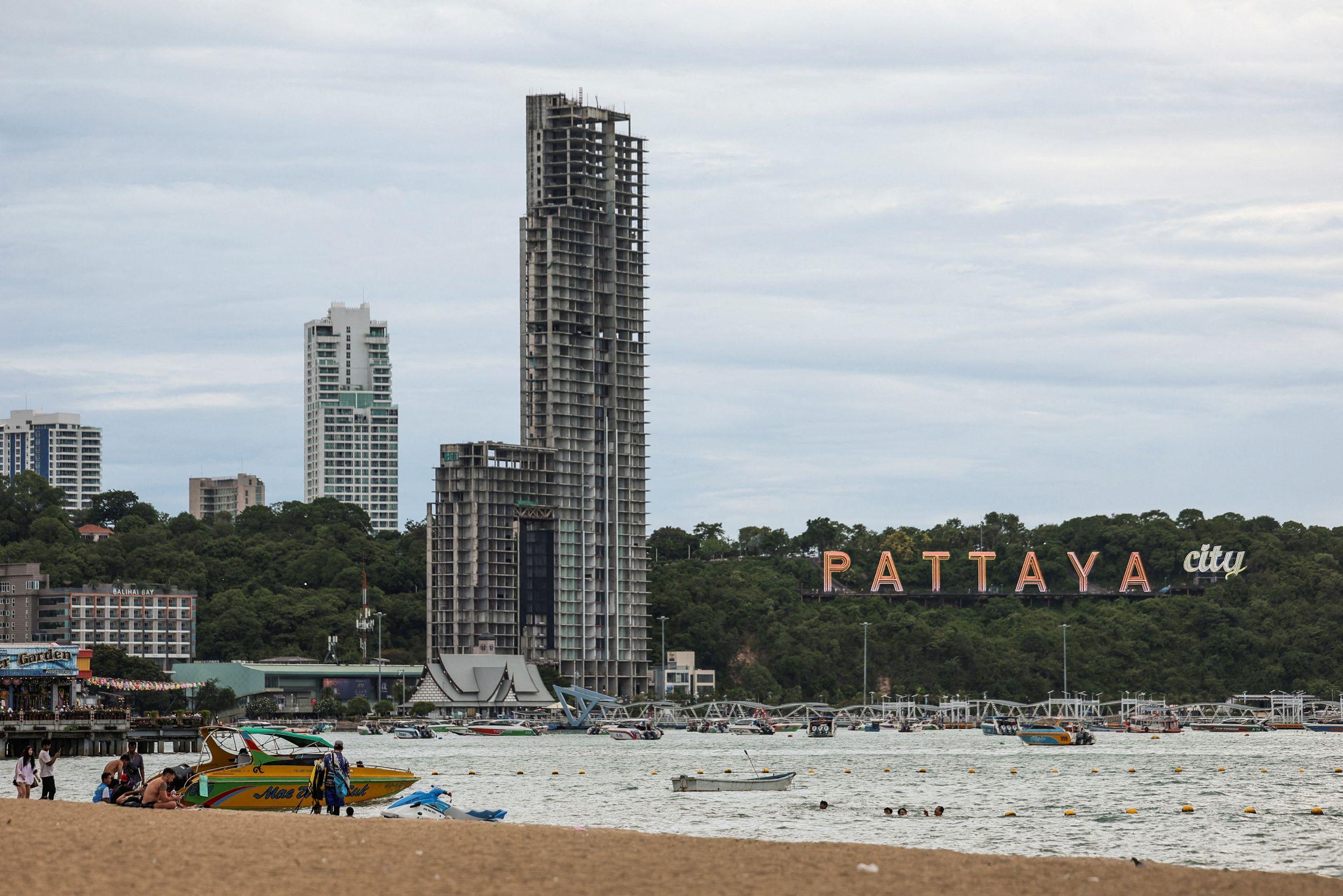 La playa de Pattaya con unos edificios al fondo y un cartel que dice Pattaya City