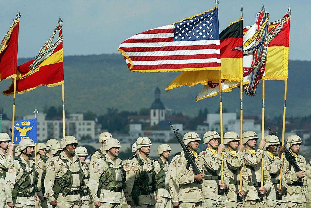 Soldados estadounidenses desfilan portando banderas durante una ceremonia militar en Alemania.