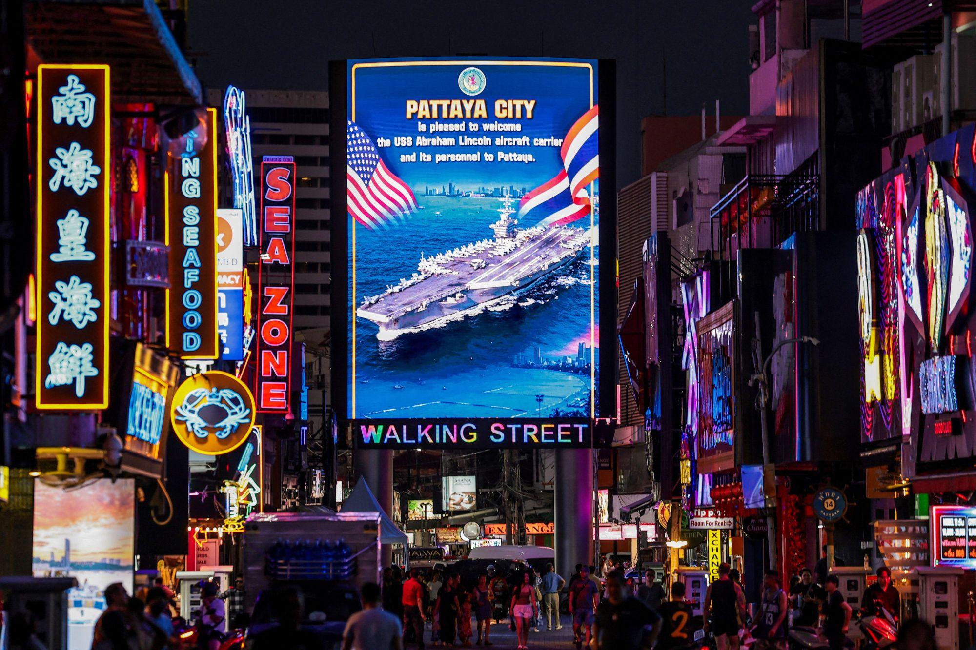 Neones en Walking Street, Pattaya, donde se ve un enorme cartel que da la bienvenida a los militares de Estados Unidos
