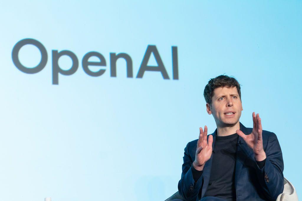 Sam Altman, CEO de OpenAI, interviene durante una charla con Masayoshi Son, CEO de SoftBank Group, en un evento en Tokio, Japón. Está sentado frente a una pantalla en la que se lee OpenAI. 