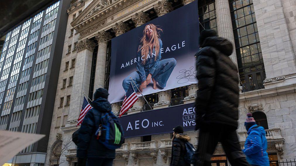 Una calle de Nueva York con un anuncio de jeans que presenta a una mujer rubia vestida con una chaqueta y pantalones de jean. 