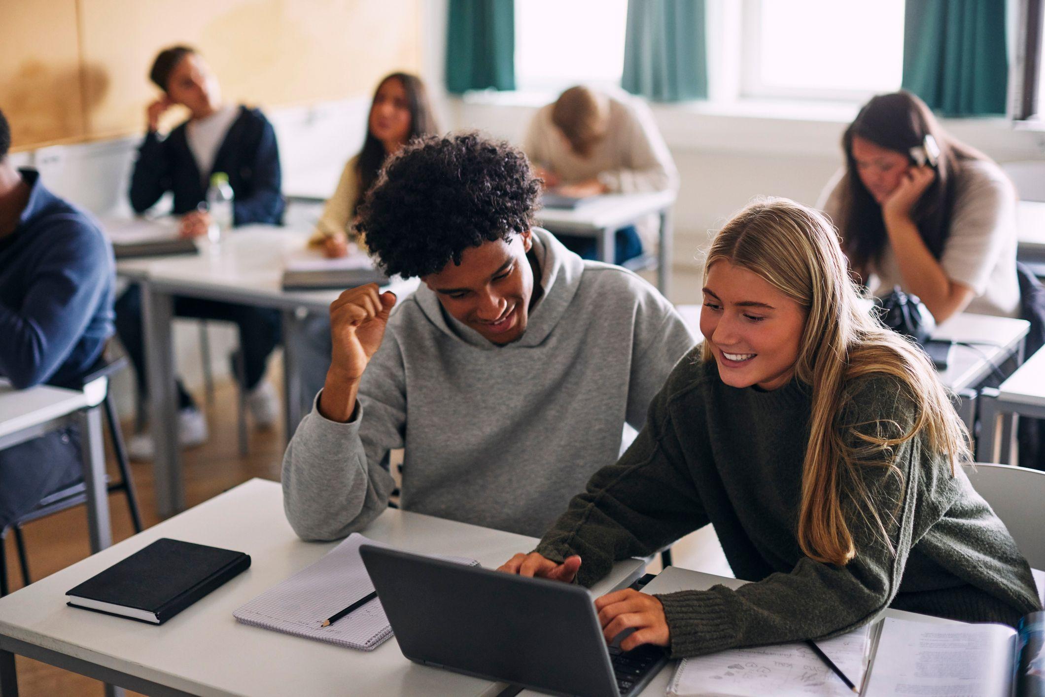 Estudiantes utilizan tecnología para realizar actividades en la sala de clase. 