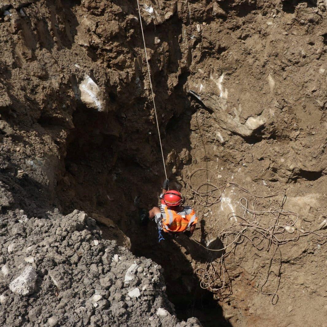 Un rescatista desciende a un agujero en una central hidroeléctrica.