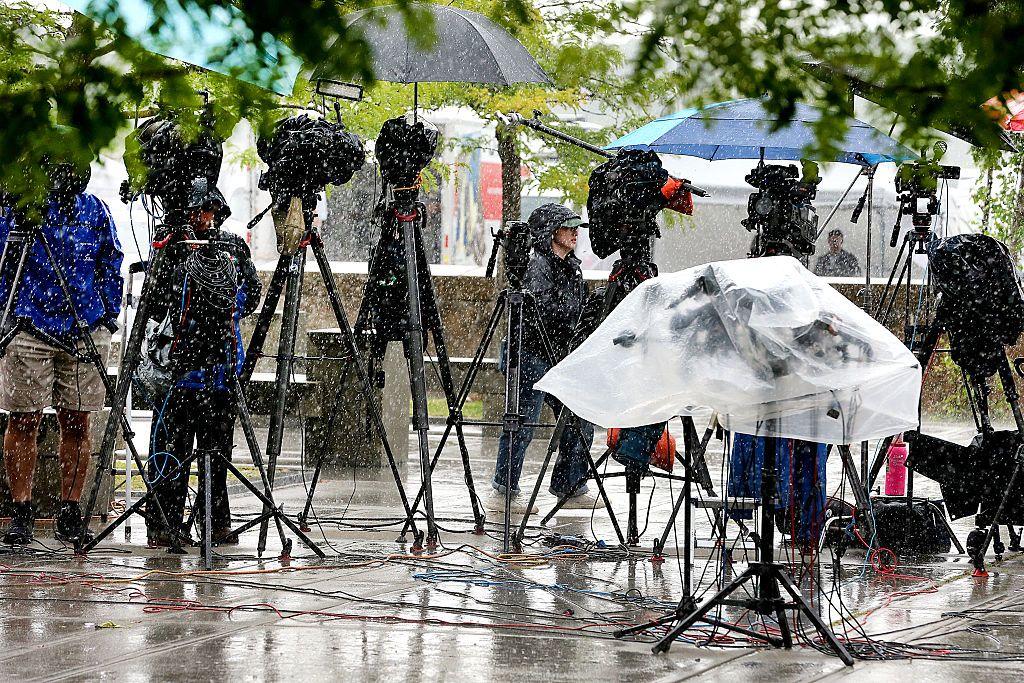 Una serie de cámaras de televisión, una al lado de la otra, cubiertas para protegerlas de la lluvia. 