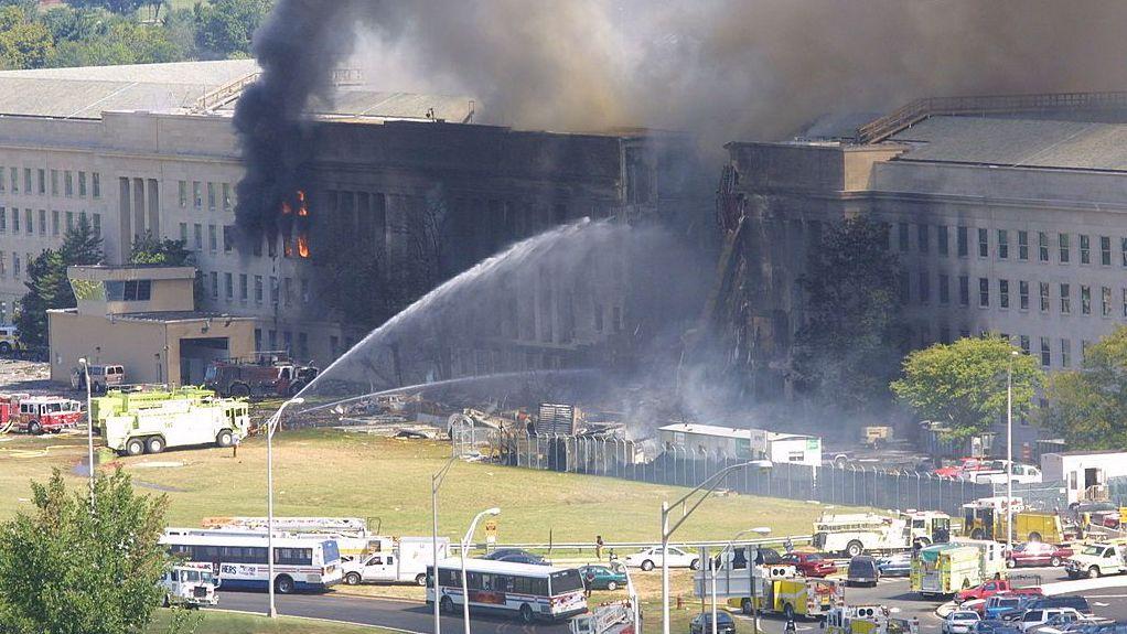 El 11 de septiembre de 2001 sale humo del ala oeste del Pentágono mientras los camiones de bomberos rocían agua en los edificios
