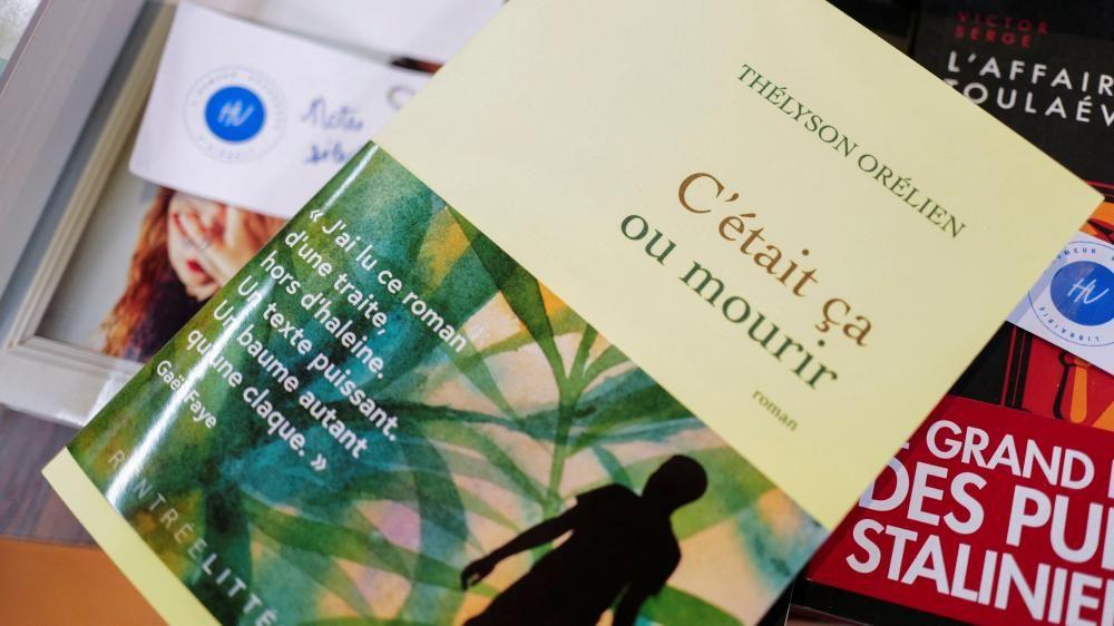 Un libro con una cubierta amarilla y escritura en francés está encima de otros libros.