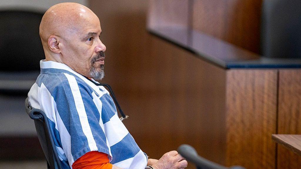 Douglas Carter comparece en una audiencia de fianza en Provo, Utah. Viste una camisa a rayas con una camiseta naranja debajo, es calvo y lleva barba de chivo.
