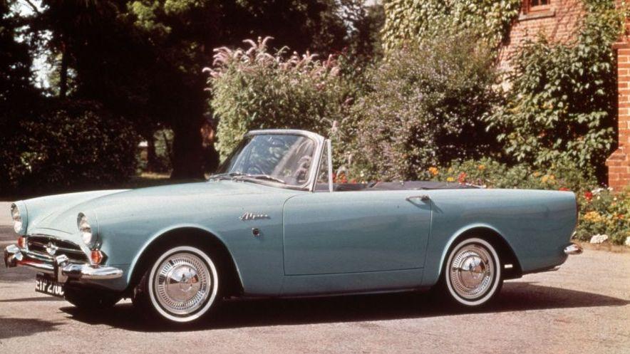 Un automóvil Alpine Sunbeam, convertible, color azul claro. 