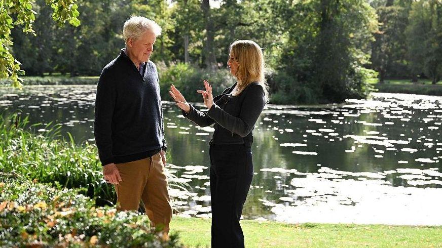 Charles Spencer junto a Laura Kuennsberg en su finca de Althorp, con un lago visible al fondo