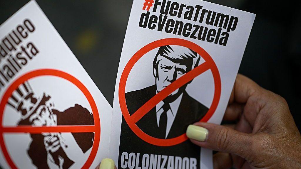 Una mujer sostiene folletos con la imagen del presidente de EE. UU., Donald Trump, y el Tío Sam durante una protesta contra la injerencia de EE. UU. en Venezuela, el 4 de agosto de 2026 en Caracas.