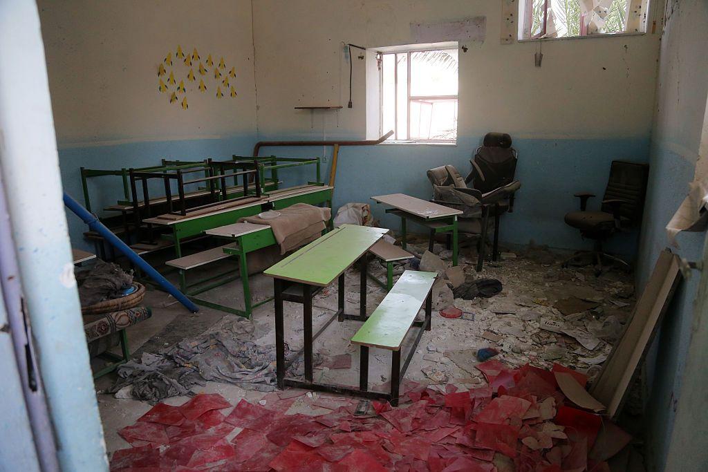 Interior de una escuela dañada en un ataque llevado a cabo por EE.UU. e Israel, en Minab. Se ve parte de la pared rota y bloques de cemento en el piso. 
