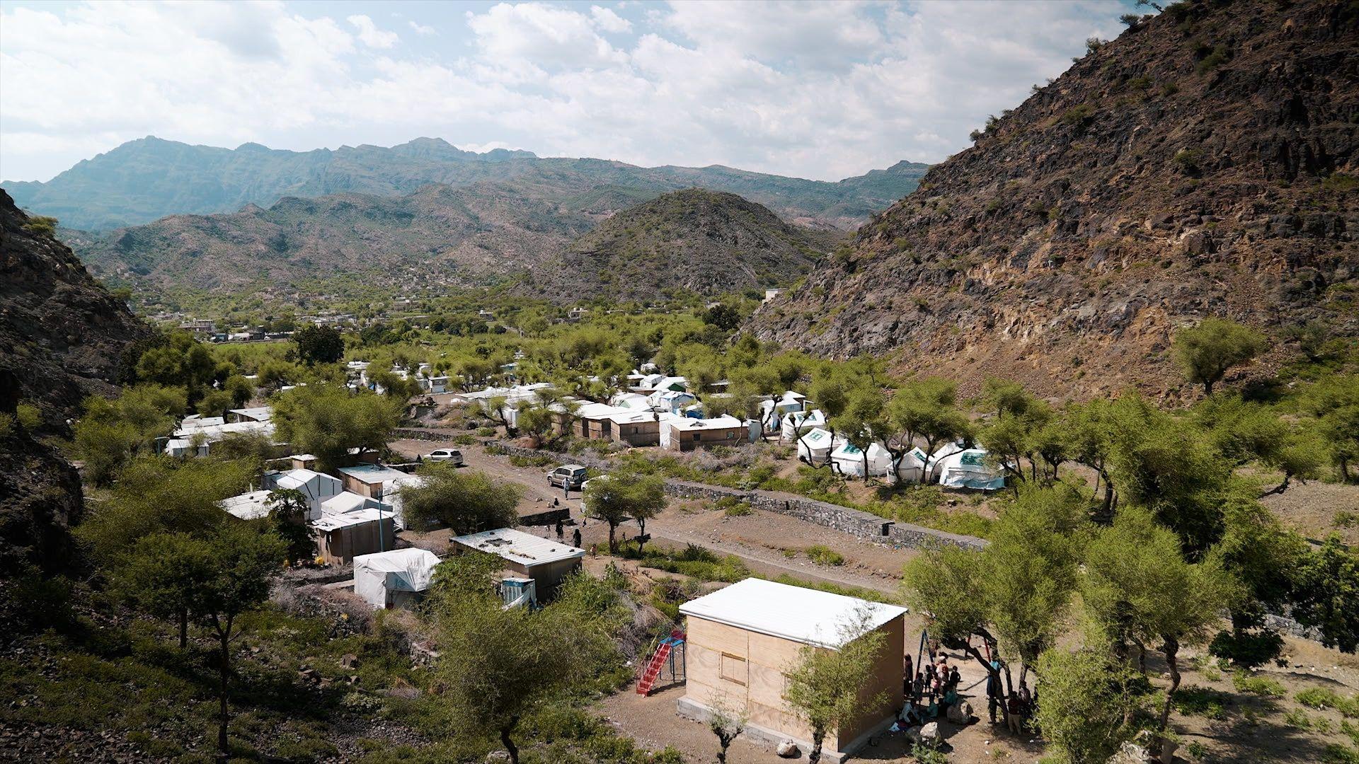 En el campamento de desplazados de Al-Monig, las tiendas se alzan entre los árboles en el fondo de un valle, rodeadas de colinas pedregosas.