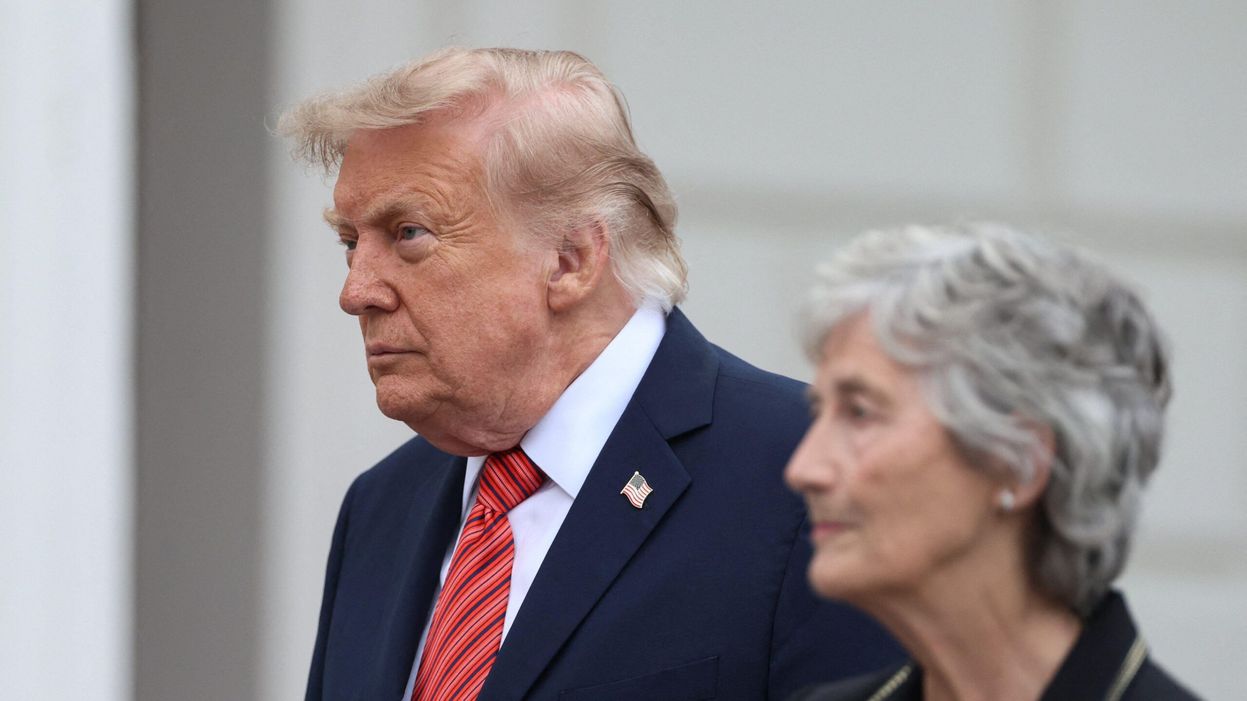 Donald Trump, de cabello gris claro, con traje oscuro y corbata roja, está de pie junto a la presidenta irlandesa Catherine Connolly, quien tiene el cabello gris corto y viste un traje negro.