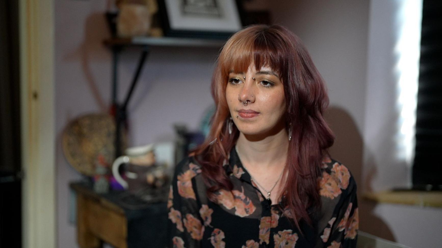 Shari, la hija de Adelle, sentada dentro de la casa de Adelle.