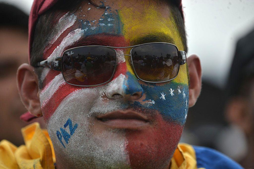 Hombre con la cara pintada con los colores de las banderas de EE.UU. y de Venezuela