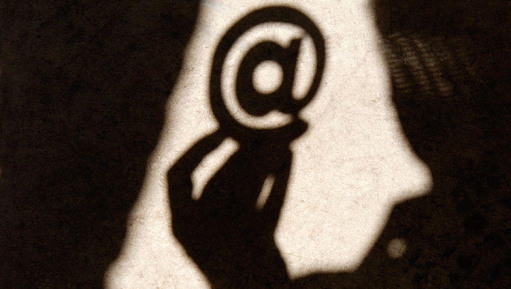 Sombra de alguien sosteniendo una @.