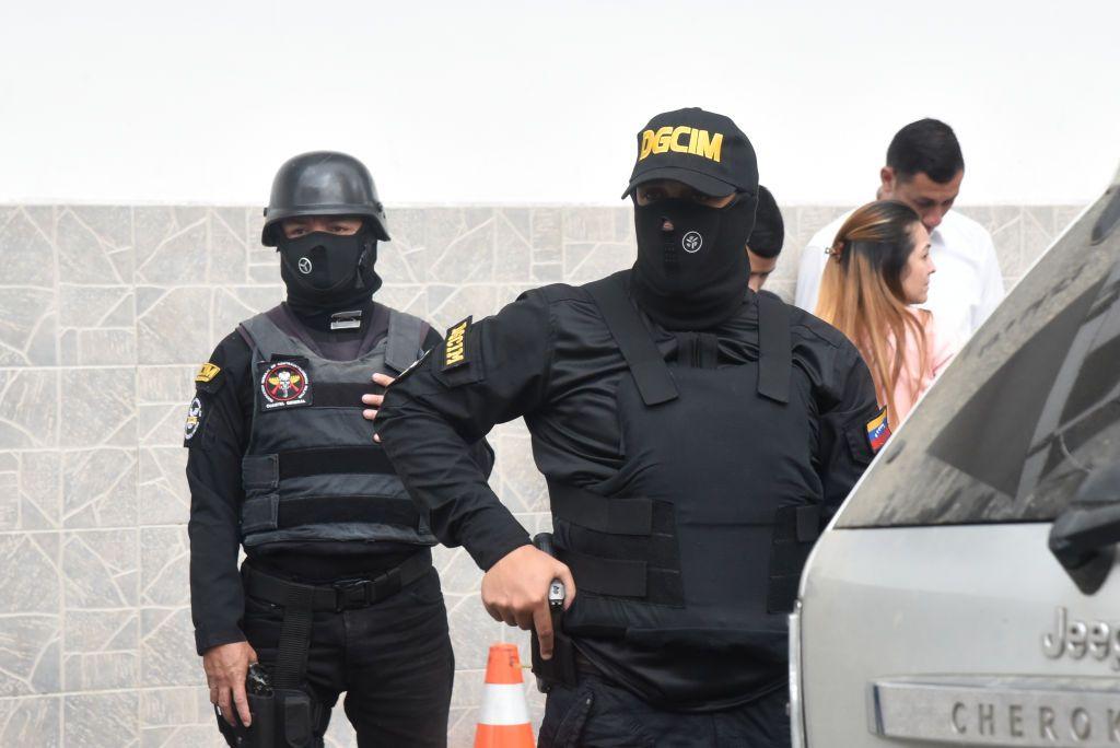 Dos agentes enmascarados y vestidos de negro de la Dirección General de Contrainteligencia Militar de Venezuela.