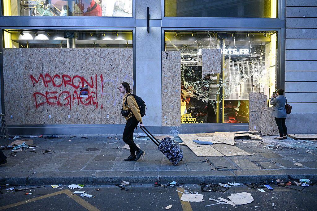 Fachada de una tienda destruida y el grafiti "Macron, dégage!" ("Macron, ¡lárgate!").