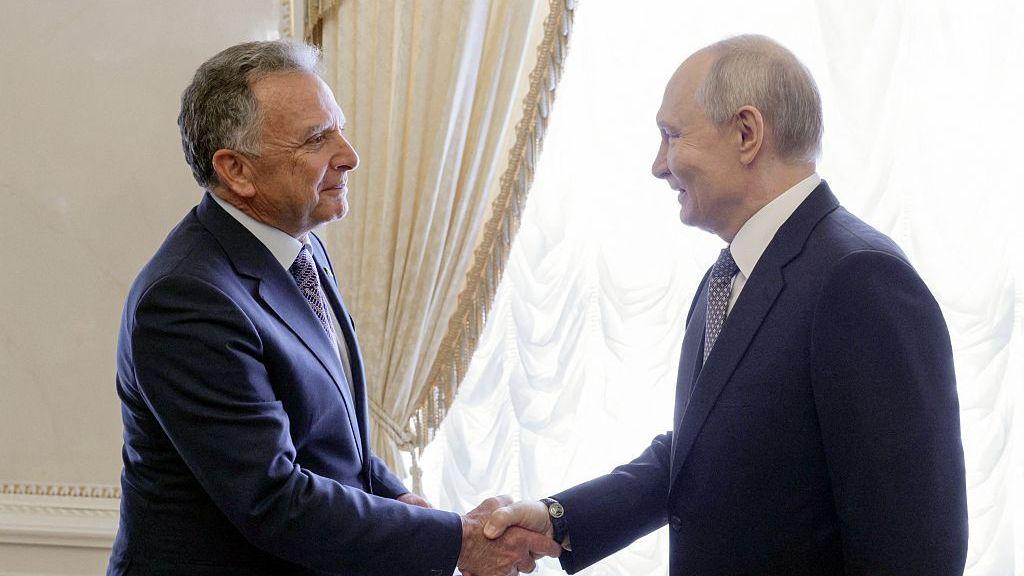 El presidente ruso, Vladimir Putin, estrecha la mano del enviado especial estadounidense, Steve Witkoff (izquierda). Ambos visten trajes azules y sonríen.
