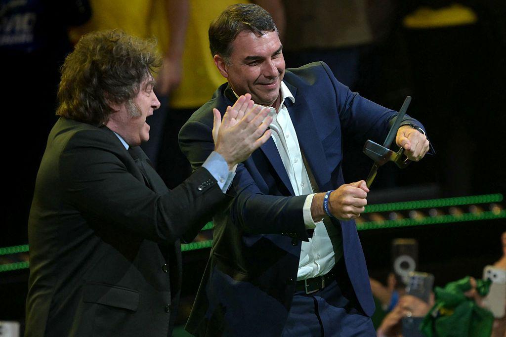 El presidente de Argentina, Javier Milei, aplaude mientras el candidato presidencial de derecha de Brasil, Flavio Bolsonaro, sostiene unas tijeras gigantes durante la presentación de su candidatura en la convención del Partido Liberal, celebrada en São Paulo (Brasil) el 25 de julio de 2026.
