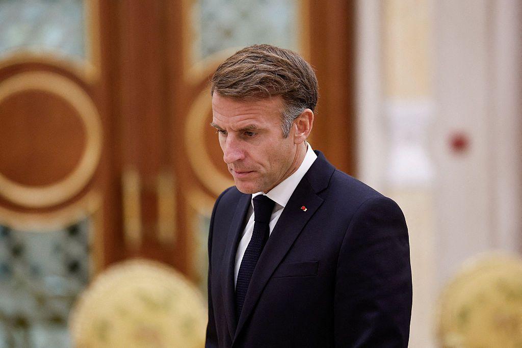 Emmanuel Macron, con americana y corbata oscuras, camina con gesto serio en una recepción oficial. 
