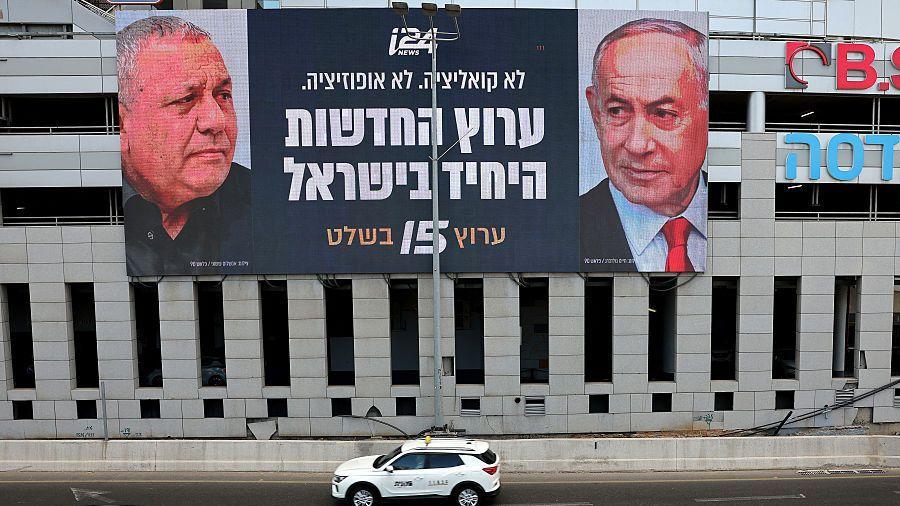 Una valla publicitaria del canal de noticias israelí i24, situada frente a un edificio en Tel Aviv, muestra los rostros de los dos candidatos favoritos en las elecciones generales.