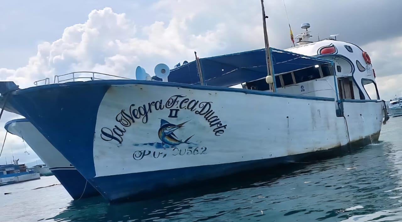 Imagen de un barco atracado en un puerto. Es de color blanco y azul y tiene escrito en su proa Negra Francisca Duarte II.