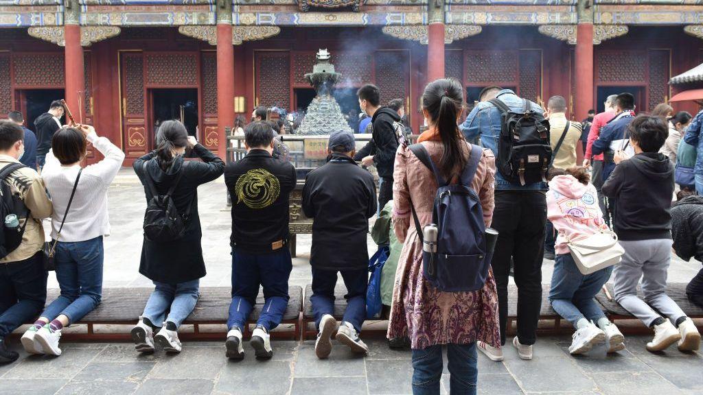 La gente sostiene incienso mientras reza en el monasterio de Yonghe. Como el templo budista de Pekín con la mayor combinación de estilos chinos Han y tibetanos, 