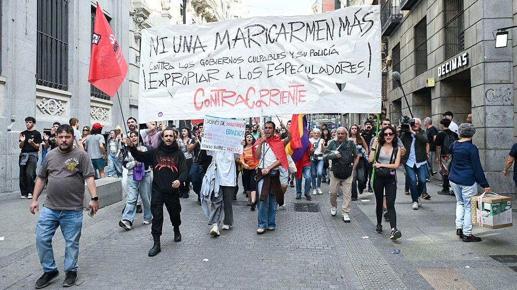 Personas marchando con una pancarta que dice 