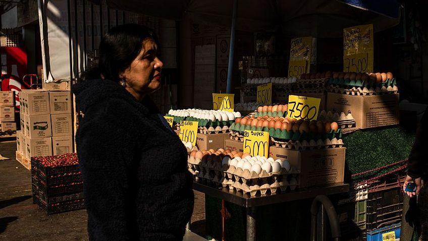 Mujer frente a canasta de huevos, Santiago