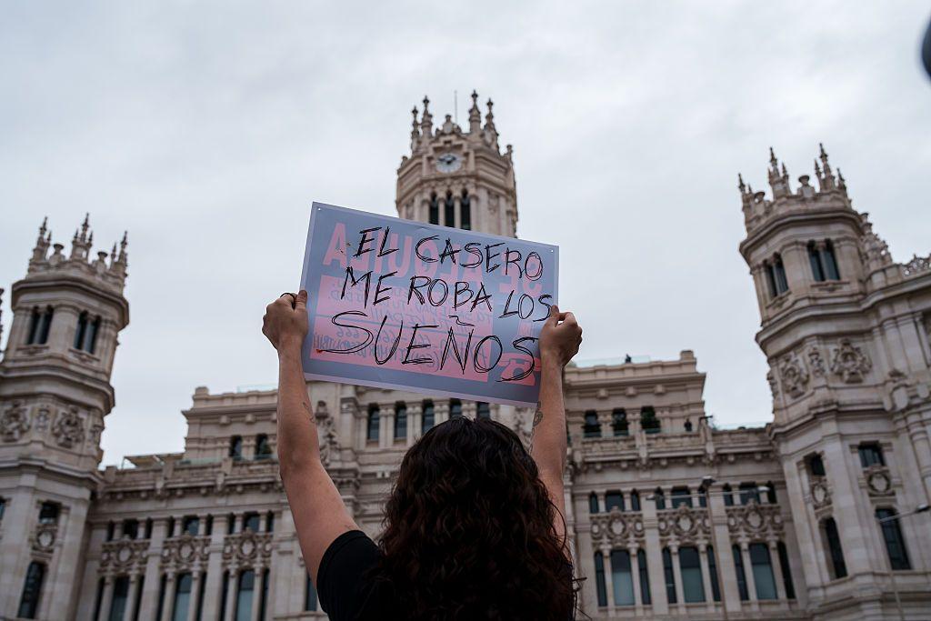 Una mujer con un cartel que dice: Mi casero me roba los sueños.