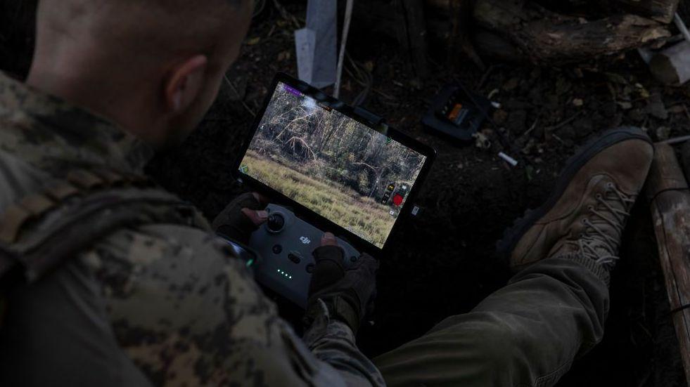 Un soldado coloca un teléfono conectado a Starlink sobre su chaleco antibalas para comunicarse con otras tropas.