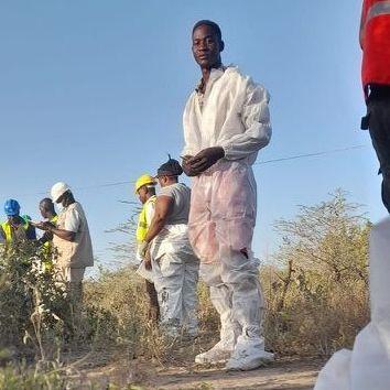 Un grupo de personas vestidas con overoles de plástico blanco endebles. Uno de ellos está mirando a la cámara