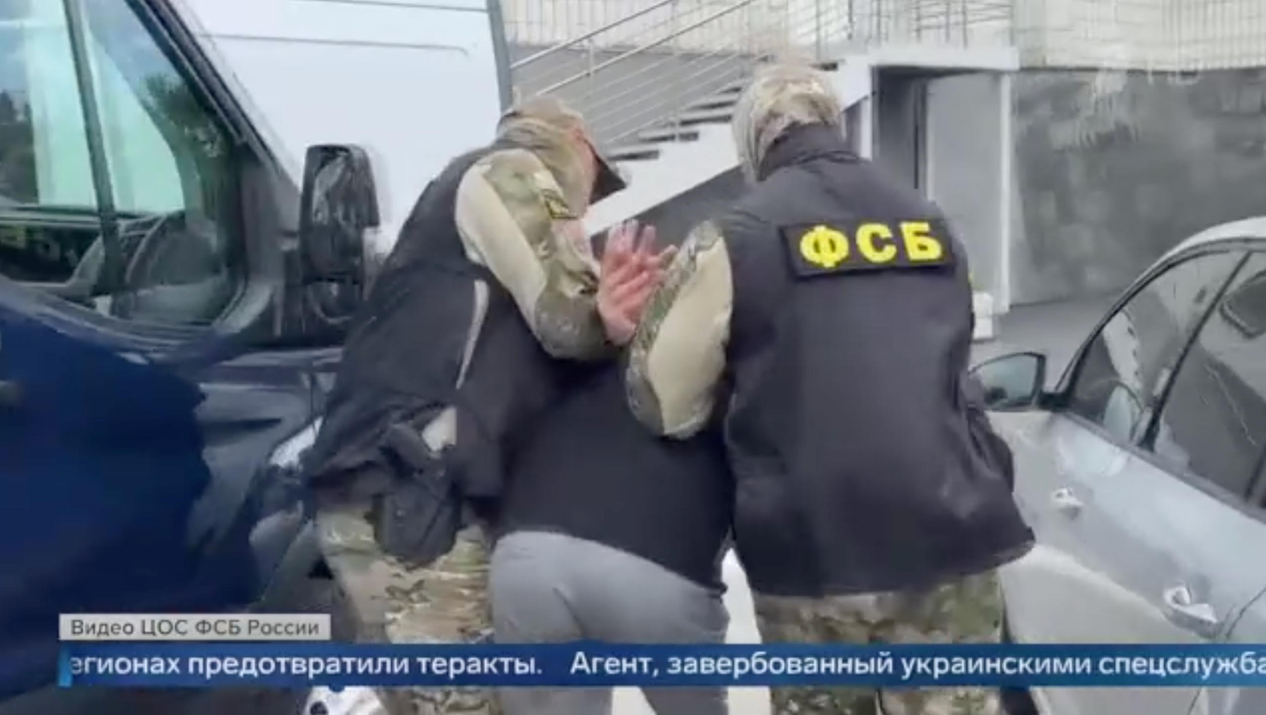 Un hombre es reducido y esposado por dos agentes del FSB. Las imágenes se están emitiendo en la televisión rusa.