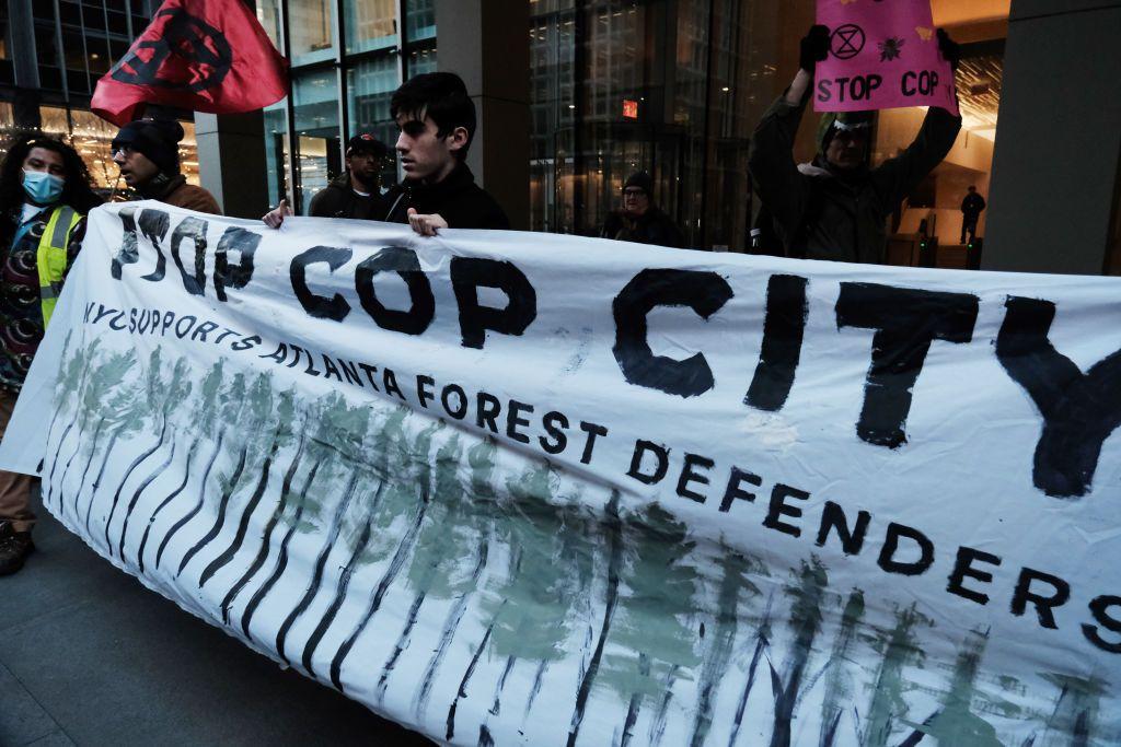 Manifestantes sujetan una pancarta con el lema "Stop Cop City". 