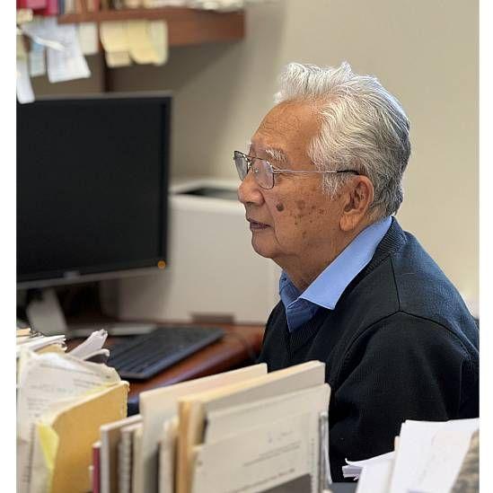 Imagen de cerca de Hiroo Kanamori trabajando frente al computador en su oficina en Caltech