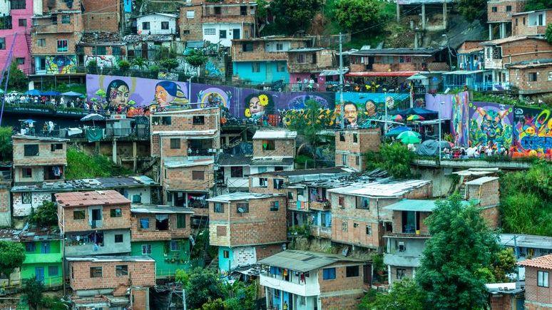 Vista panorámica a la Comuna 13 de Medellín en la que se observan murales de arte urbano.
