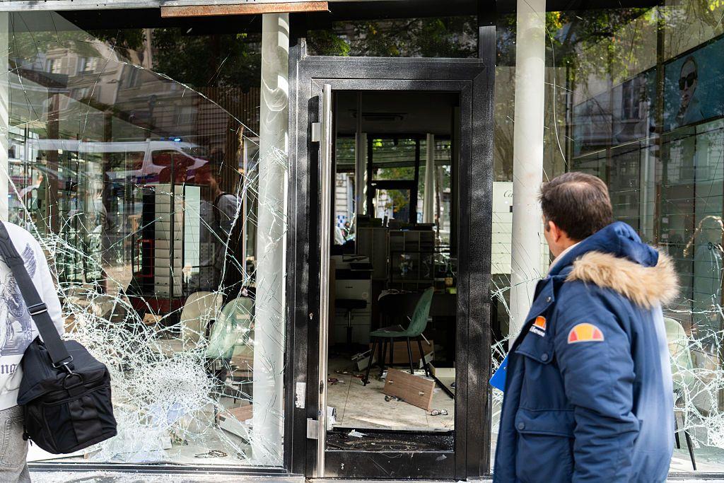 Un hombre observa los daños en los escaparates destrozados del bulevar parisino Magenta.