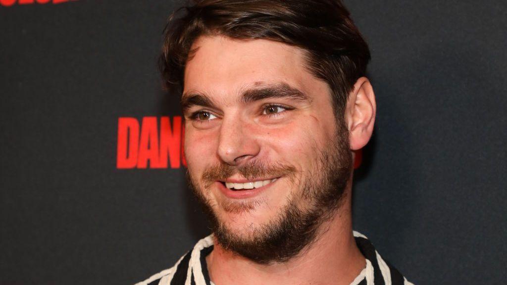 RJ Mitte asiste a un evento de alfombra roja en Los Ángeles en 2023. Está sonriendo. y tiene barba 

