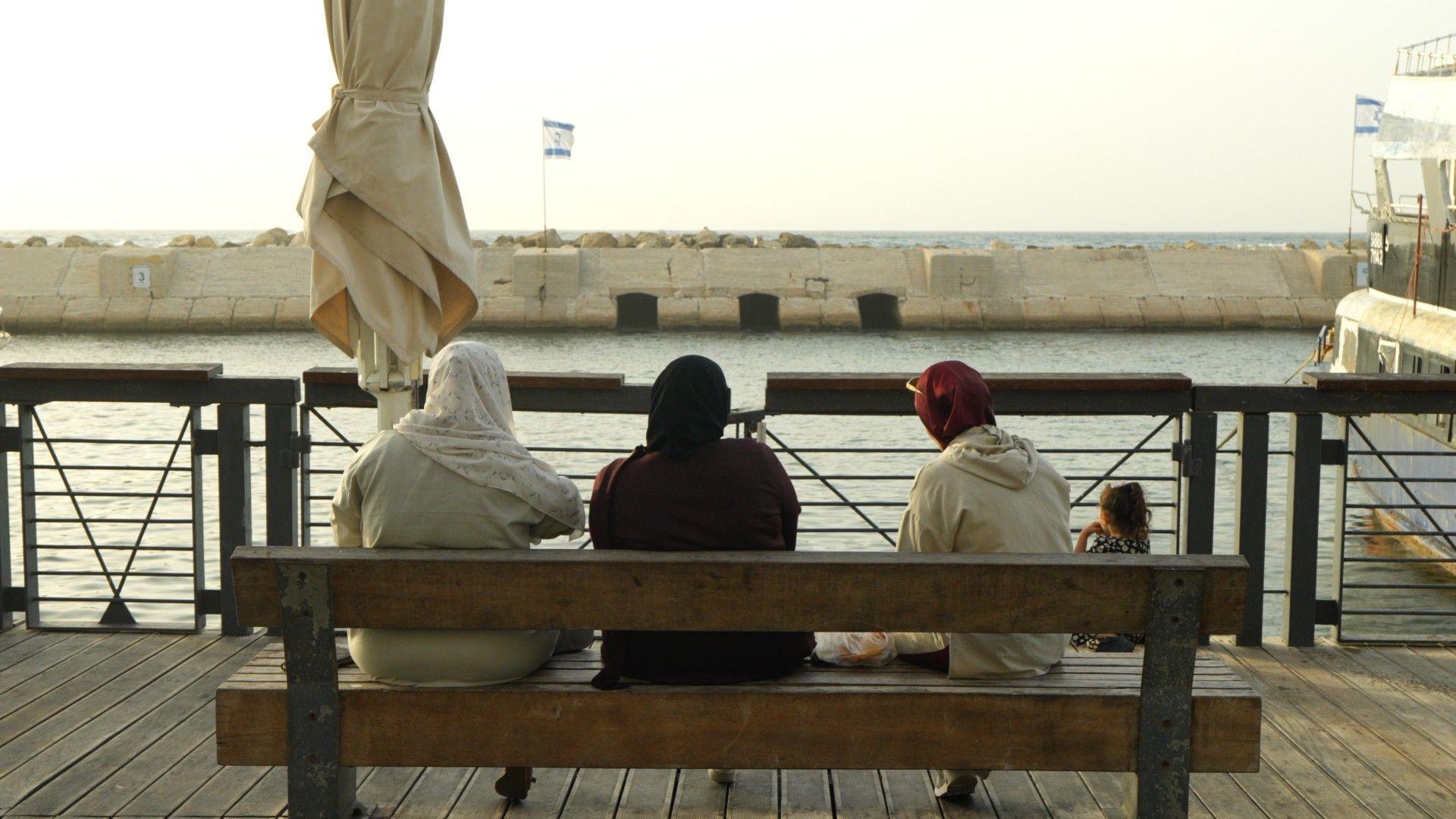 Mujeres árabes israelíes sentadas en un banco en el paseo marítimo de Jaffa.