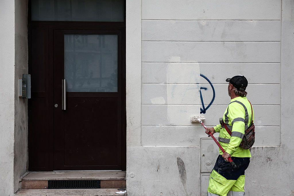 Un empleado municipal limpia pintadas de una pared, un día después de las protestas, en Marsella.