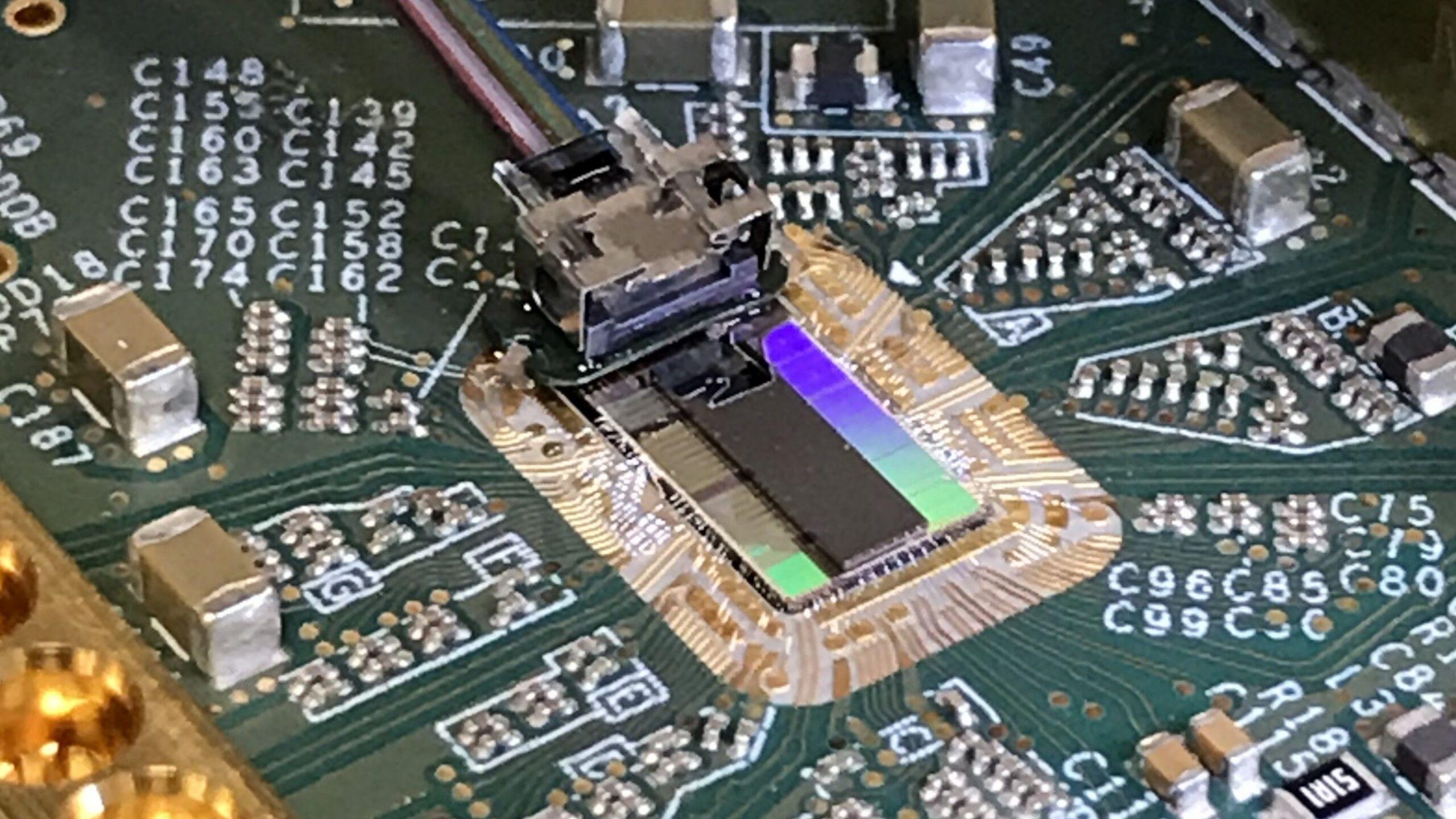 Una placa de circuito impreso que incorpora un cable de fibra óptica conectado a un chip óptico de ordenador.