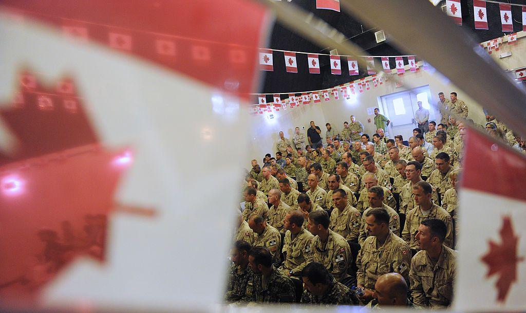 Soldados canadienses en la base que tenían en Afganistán y a su alrededor banderas del país.