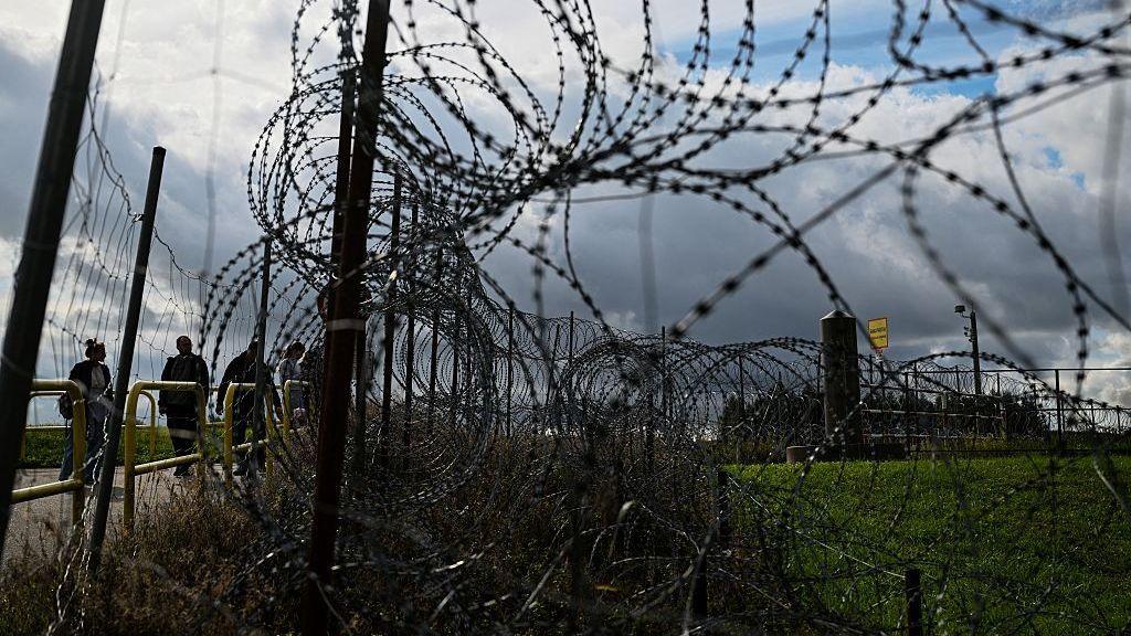 Unos turistas se encuentran junto a una valla fronteriza en la frontera entre Polonia y Lituania y el enclave ruso de Kaliningrado, el 26 de septiembre de 2026. 