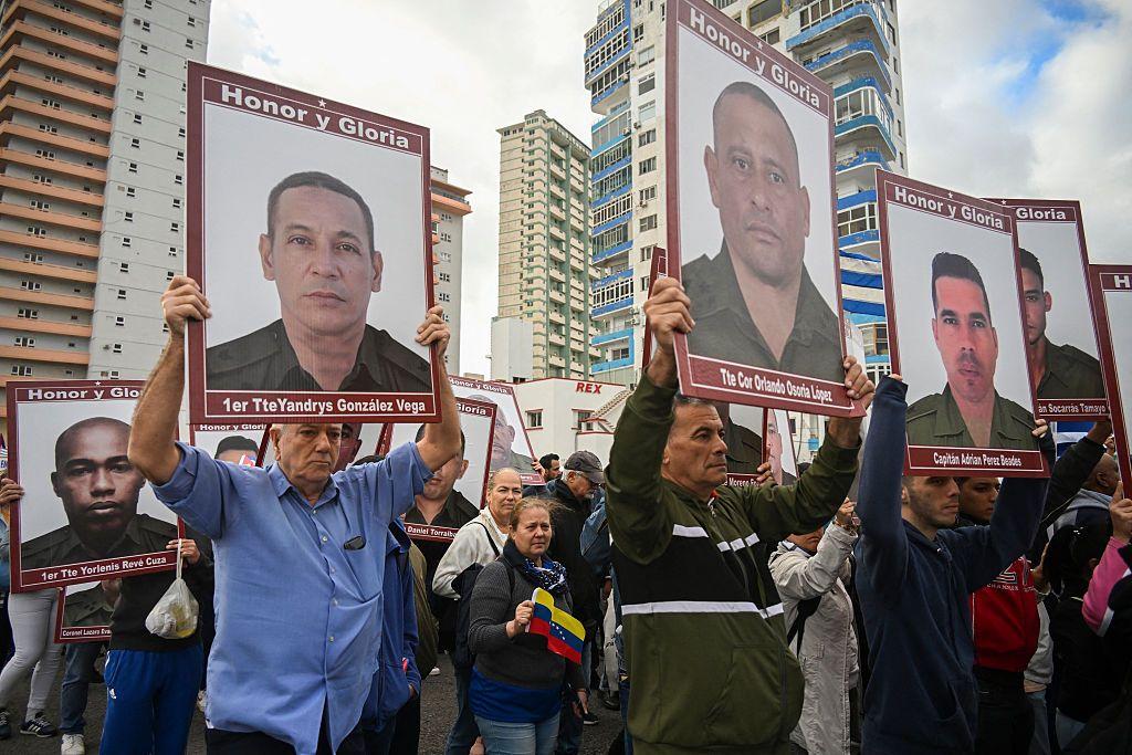 Cubanos sostienen retratos de los 32 soldados cubanos que perdieron la vida durante la incursión estadounidense en Venezuela, mientras participan en la protesta "antiimperialista" frente a la Embajada de Estados Unidos en La Habana, el 16 de enero de 2026.